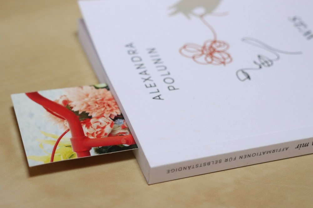 Ein Lesezeichen von einem Fahrrad steckt in einem Buch von der Autorin Alexandra Polunin